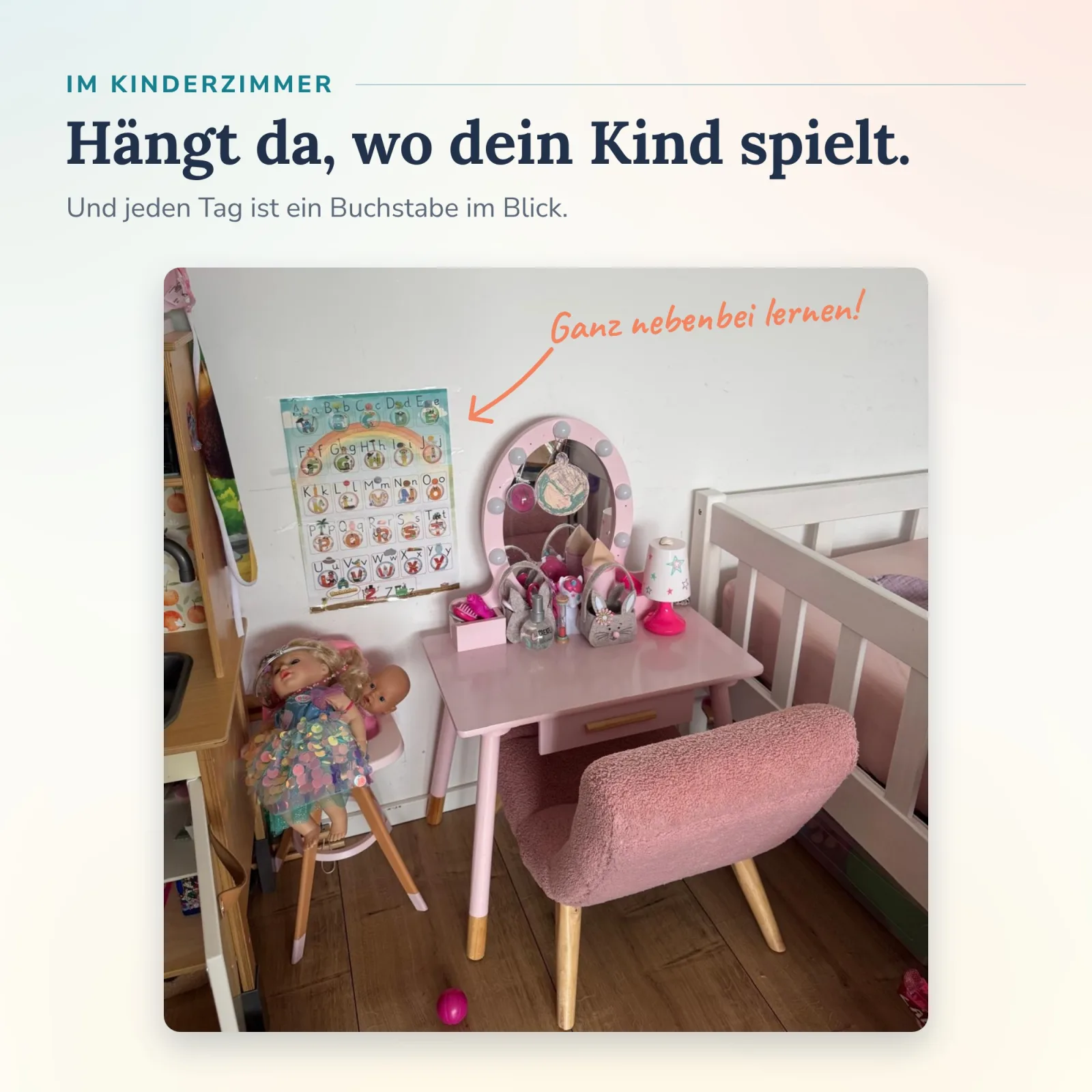 ABC-Lernplakat von Alonies an der Wand im Kinderzimmer neben Schminktisch und Puppe – Buchstaben nebenbei selbständig und spielerisch im Blick.